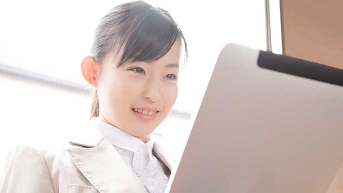 電車内でタブレットPCを使っているOL