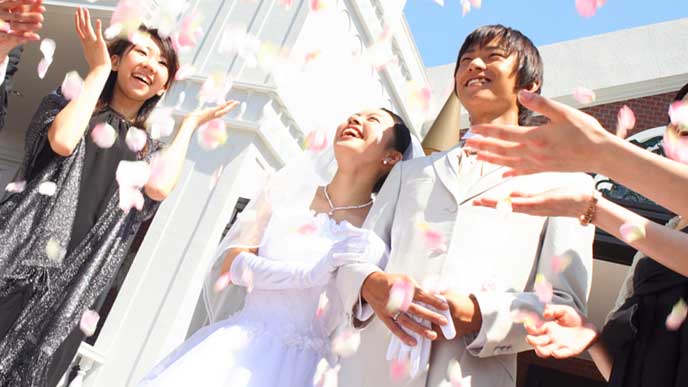 結婚式で皆に祝福される新郎新婦