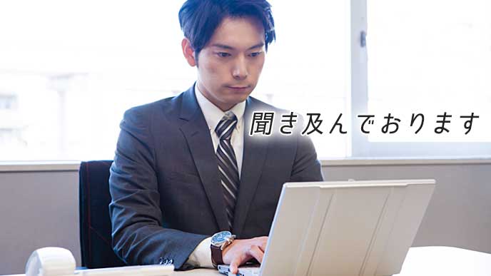 ノートパソコンを使い、取引先の相手にメールを送信している会社員