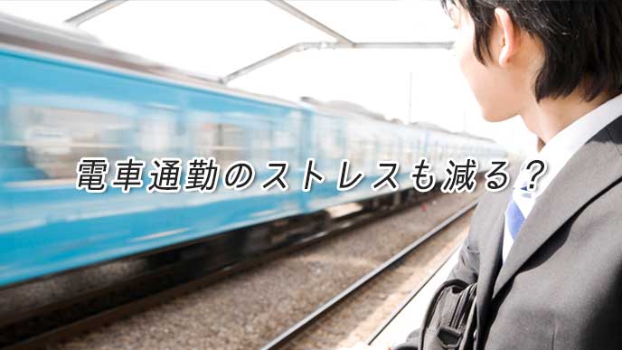 駅のホームで通勤用の電車を待っているサラリーマン