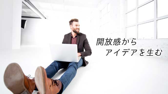 明るく広い部屋でノートパソコンを使っている男性