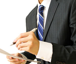 青系のネクタイでメモをとるビジネスマン