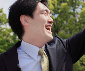 緑系のネクタイで笑顔のビジネスマン