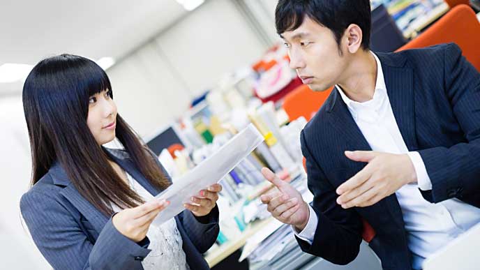 上司に書類を提出するOL