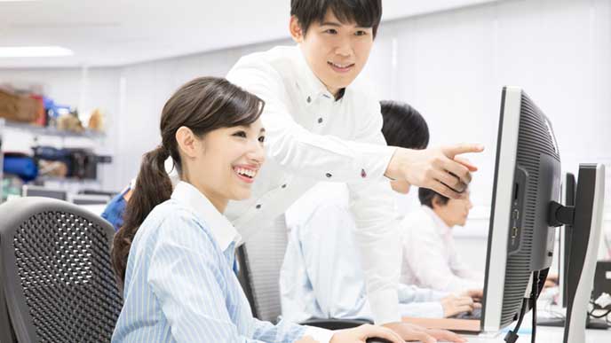 新入社員の女性に仕事を教えている会社員