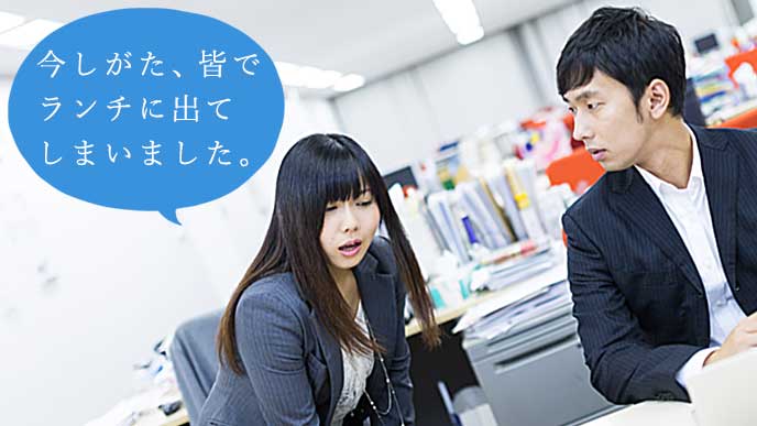 オフィスで上司に謝っているOL