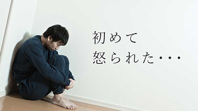 部屋の隅で落ち込んでいる男性