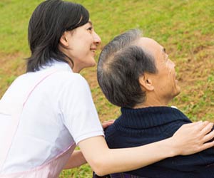 老人の肩を支える生活相談員