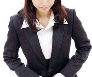 スーツを着てお辞儀する女性
