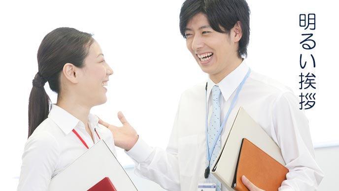 笑顔で女性の同僚と会話する男性社員