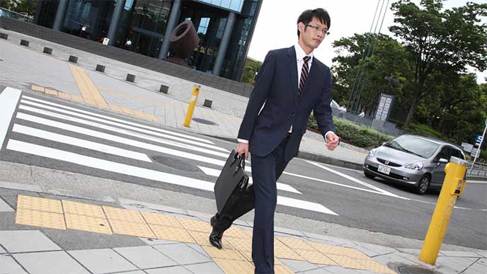 営業に歩くスーツを着た男性