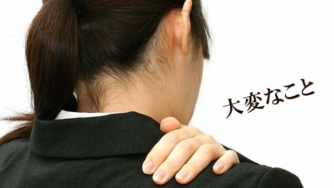 肩を手で押さえる女性事務員