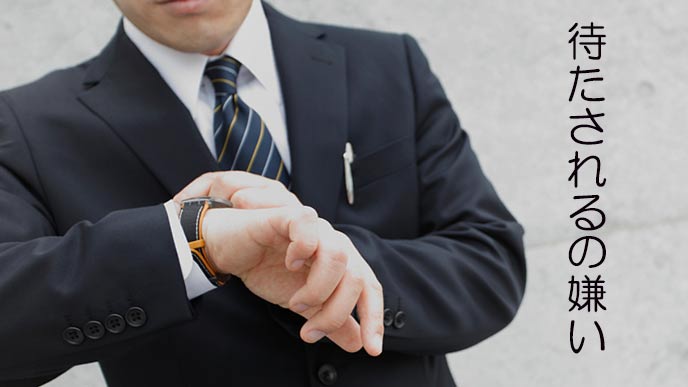 腕時計を見て苛立つビジネスマン