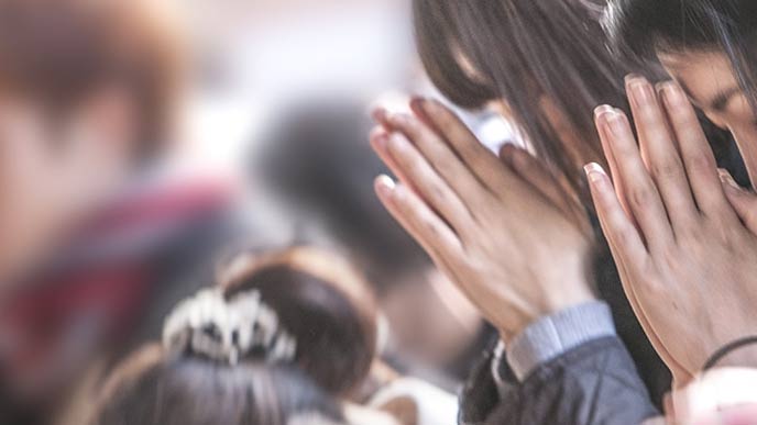神社で合掌する男性