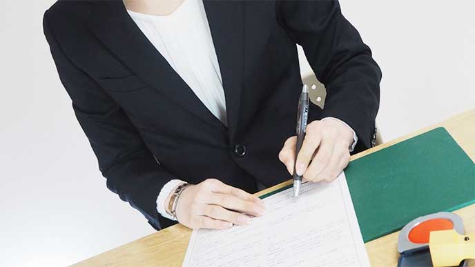 契約書にサインをする女性社員