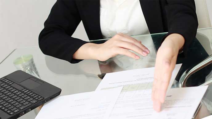 契約書を提示して話をしてる女性社員