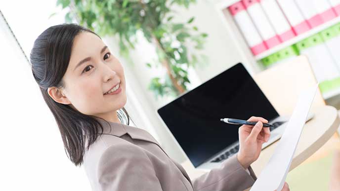 メモを取りながら仕事をしてる女性