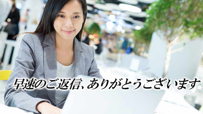 ラップトップで返信メールする女性