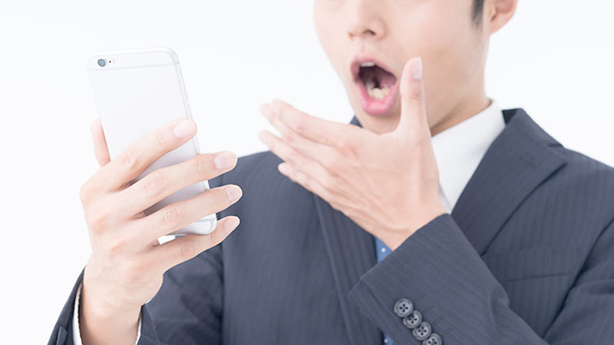 スマホを見て驚く男性の表情