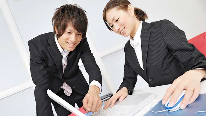 男性社員から仕事を教わる女性新入社員