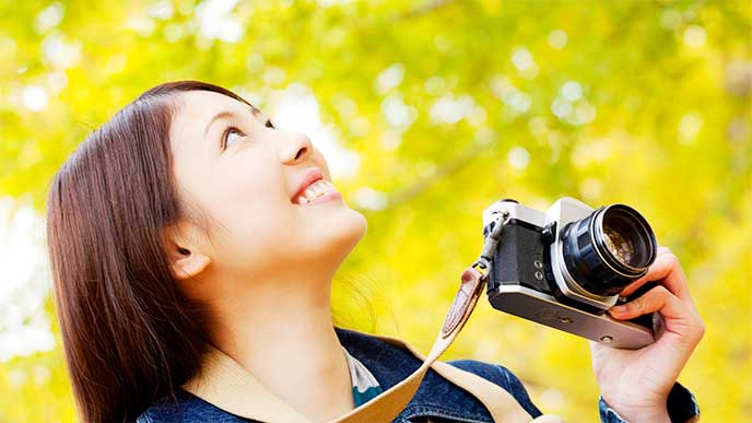 カメラを手に景色を見てる女性