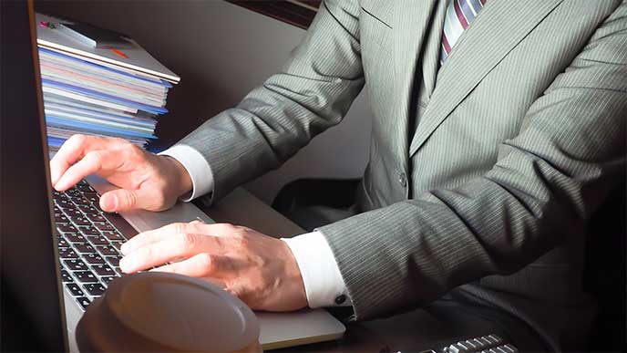 残業で暗くなっても仕事をしてる男性社員