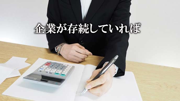 電卓を見ながらノートに記載する女性事務員