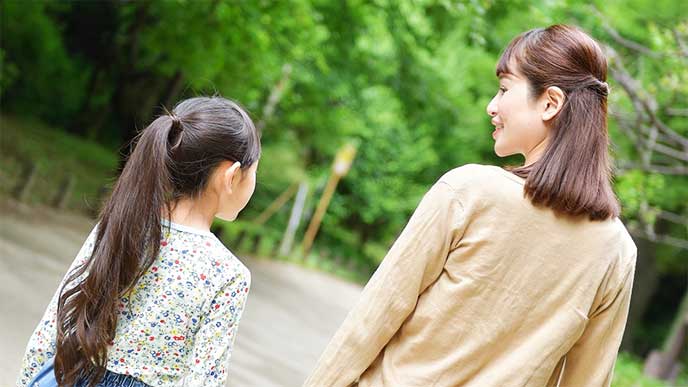 子供と一緒に歩いてる母親
