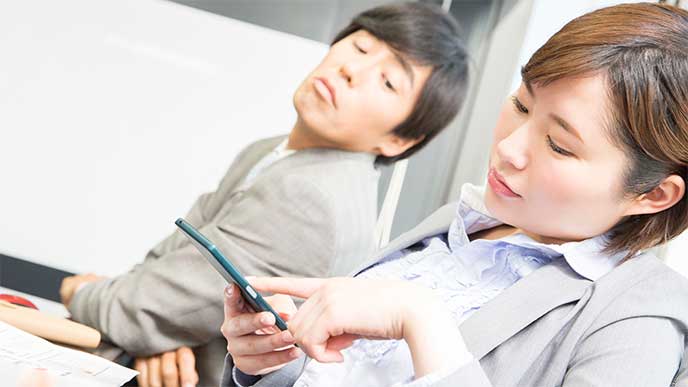 仕事中にスマホを操作する女性