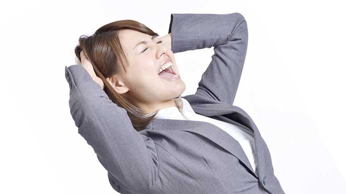 イライラして頭をかきむしってる女性