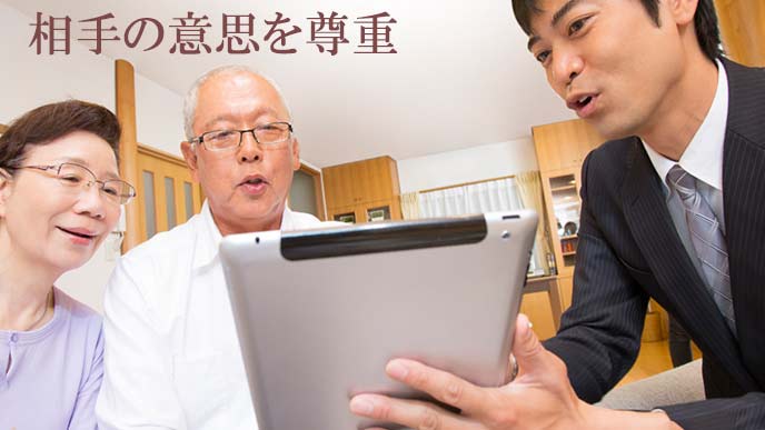 年寄り夫婦に説明する営業マン