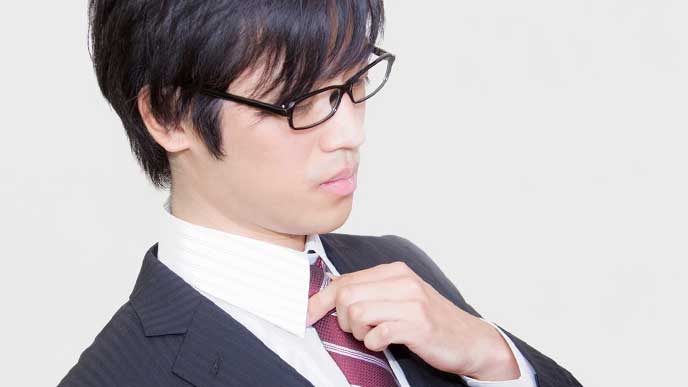 ネクタイを締めなおす社員