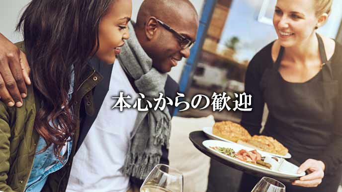 料理を出しながら笑顔で接する女性