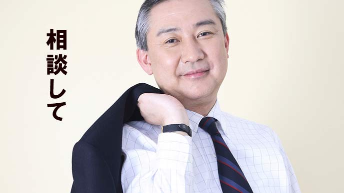 肩に背広を担ぐ年配のビジネスマン