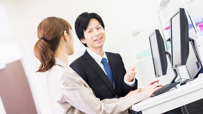 上司に早退することを報告してるOL