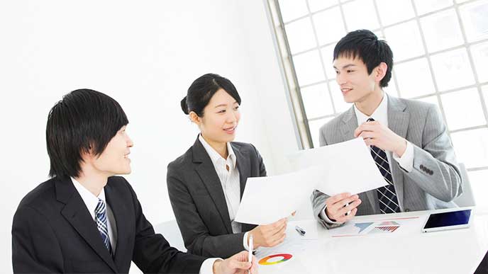 オフィスで話をしてるスーツを着た男女