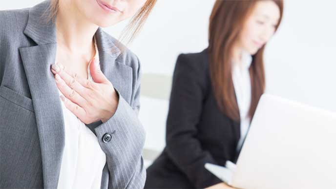 安心して胸をなでおろしてるスーツを着た女性