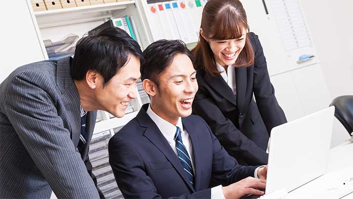 笑顔を仕事の相談してる会社員たち