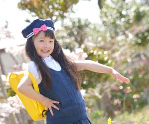 保育園の前でポーズをとる園児