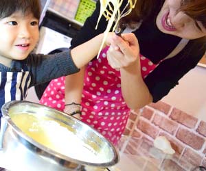 子供と一緒に料理をするママ
