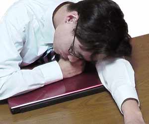 職場のデスクで眠る疲労した社員