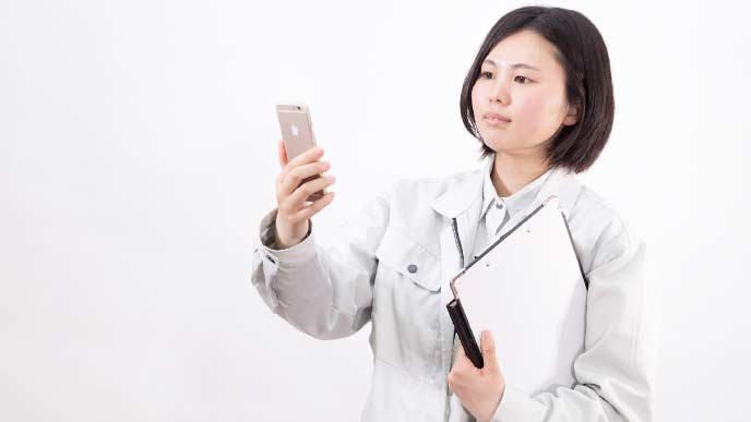 名刺管理アプリを使う女性の現場監督