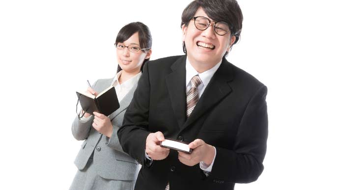 名刺を差し出す男性社員とあたたかく見守る女性社員