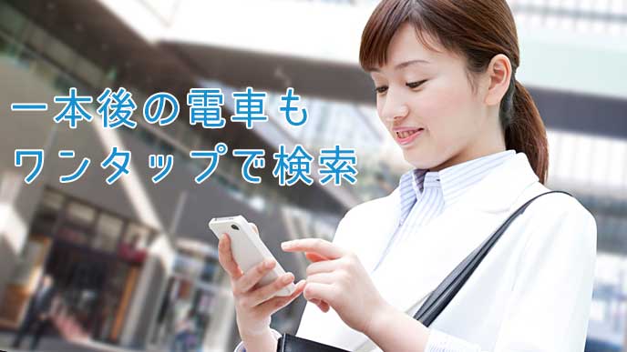 駅でスマホアプリを使っている会社員の女性