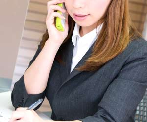 電話で相談している女性社員