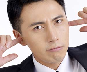 指で耳を塞ぐ男性