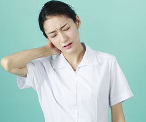 疲労して首筋に手をやる看護師