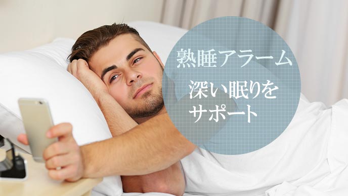 目覚めてスマホを取る男性