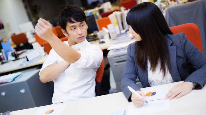 腕まくりをして筋肉アピールをする男性社員