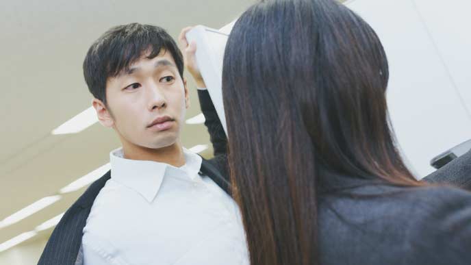 コピーをとっている女性社員を上から見ている男性社員